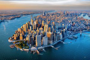 Aerial view of Manhattan Island with surrounding water and densely packed buildings