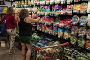 Food shoppers search for vegetables July 1, 2023 at the Hannaford supermarket in South Burlington, Vermont. The inflation rate for food and other durable goods was 9.7% in May, 2023.
