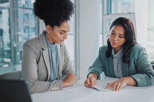 An investor meeting with an advisor meet to discuss tax-efficient portfolio moves while sitting in an office. 