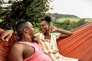 Couple sitting on a hammock.