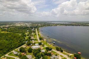 Aerial view of a lakeside town with residential areas and a large body of water on the right