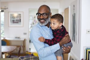 An adult holding a young child in a home setting