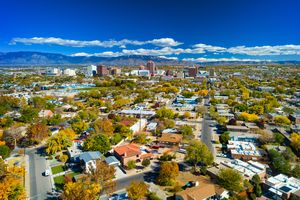 Aerial view of Albuquerque New Mexico showing buildings and residential neighborhoods with mountains in the background