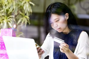 Woman looking at computer and credit card information