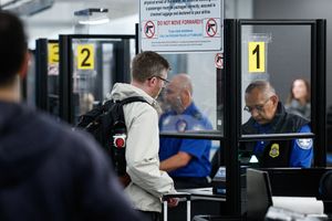 Man interacting with an airport security officer at a counter