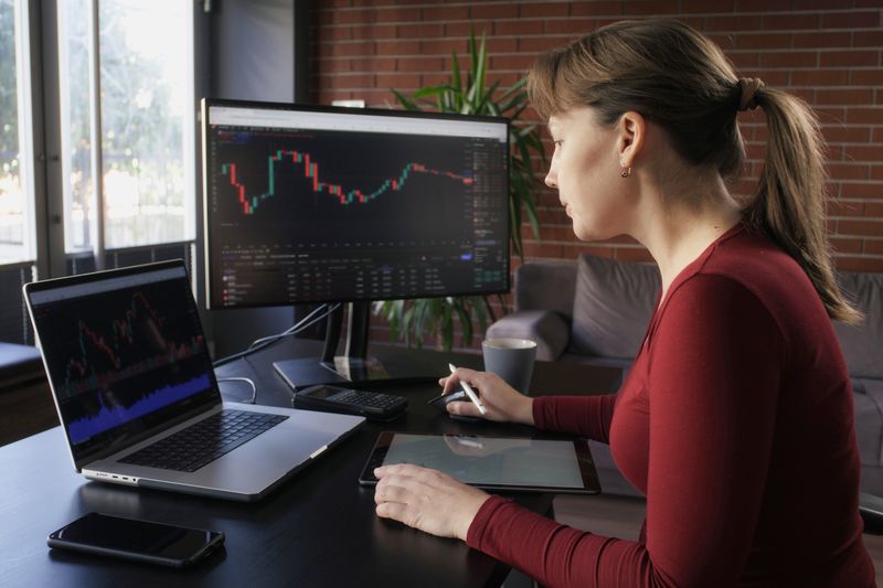 Trader working on two screens during a trading session.