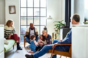 A group of people sitting and interacting including a child being entertained by an adult