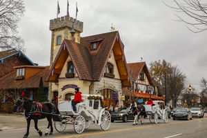 Horsedrawn carriages passing in front of a Bavarianstyle building