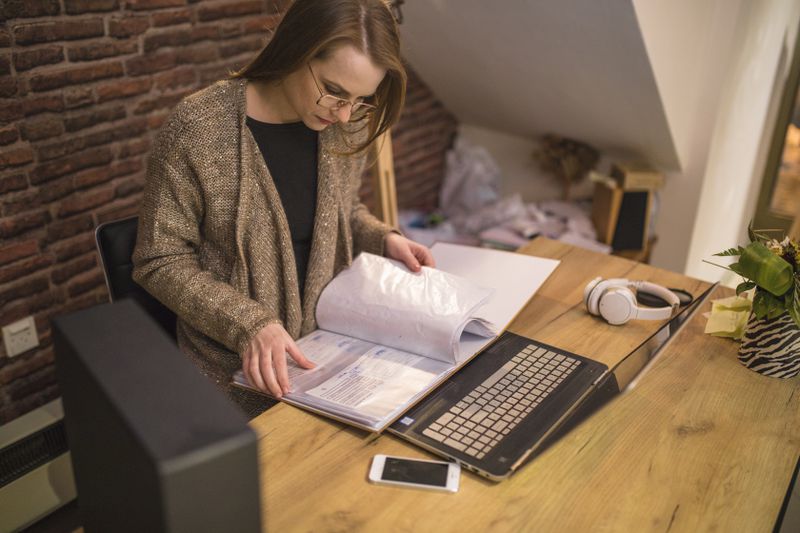 Woman sitting at a desk in her home studying documents