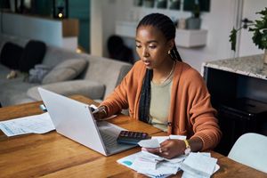 A woman with a calculator and a computer