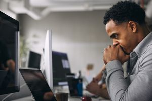 A frustrated man sitting at a computer