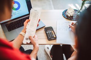 An over the shoulder shot of a young mother and her teenage daughter working together to manage their household budget