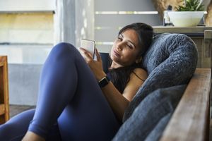 Person lounging on a couch looking at a phone casual indoor setting