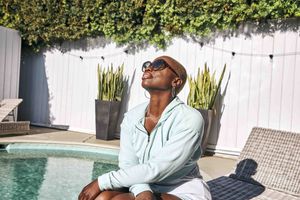 A woman basks in the sun by a pool.