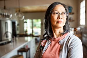 A woman standing in a kitchen looking to her right.