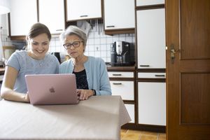 Two women at a laptop in a kitchen